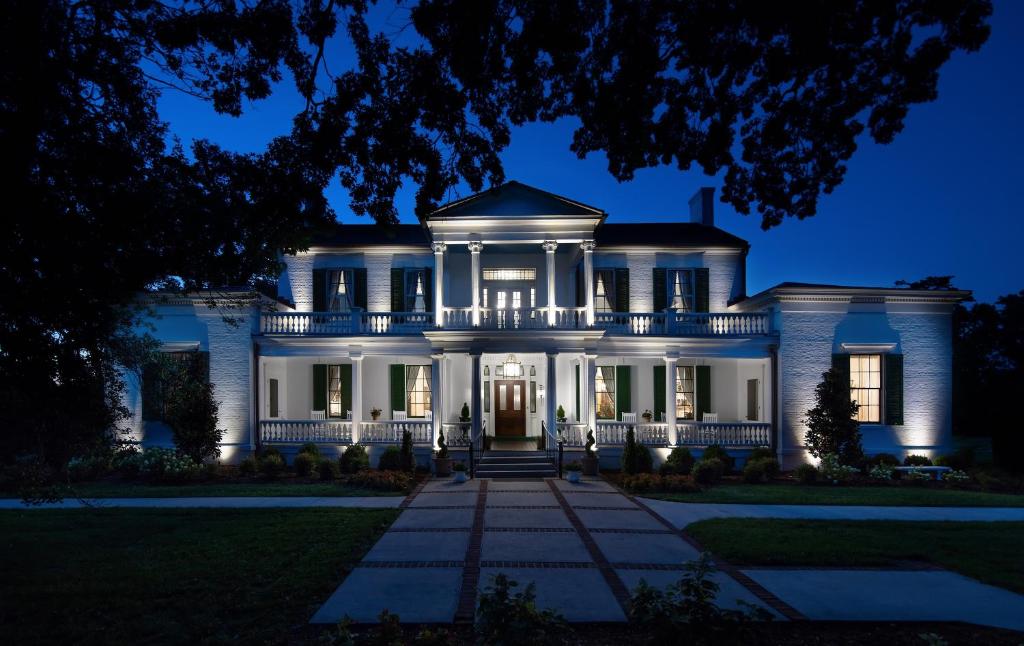 uma grande casa branca à noite em Belle Air Mansion and Inn em Nashville