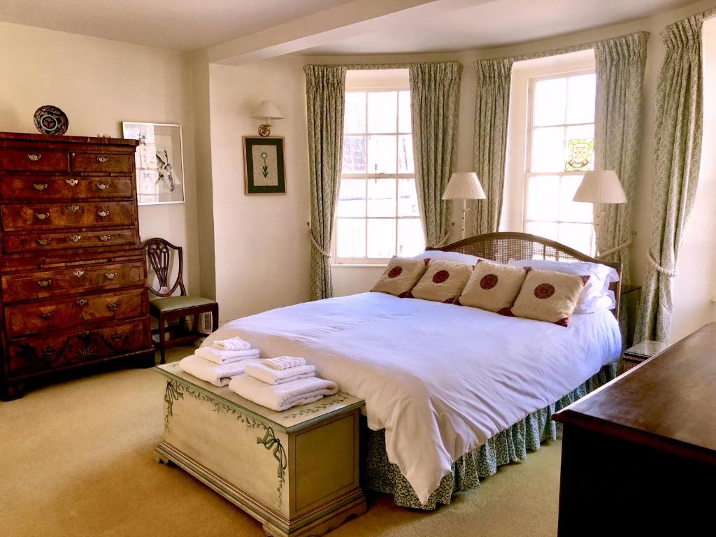 a bedroom with a bed and a dresser and windows at Lauras Townhouse Apartments The Circus Maisonette in Bath