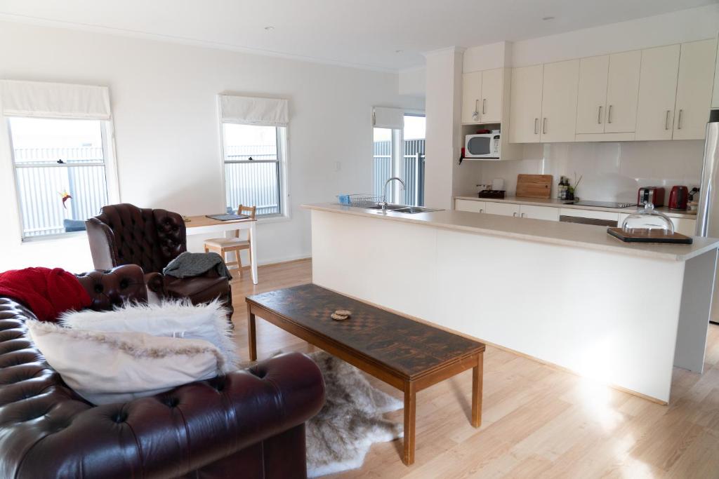 a living room with a couch and a table and a kitchen at Gawler Townhouse 1 Bedroom in Gawler