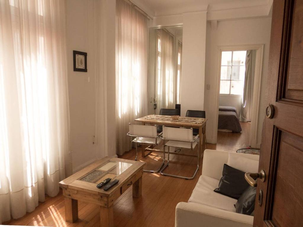 uma sala de estar com um sofá e uma mesa em Silencioso departamento antiguo em Buenos Aires