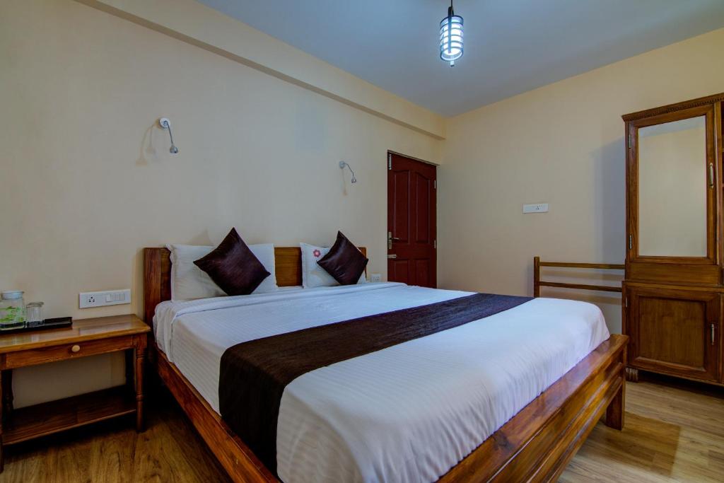 una camera con un grande letto bianco di The Abode a Ooty