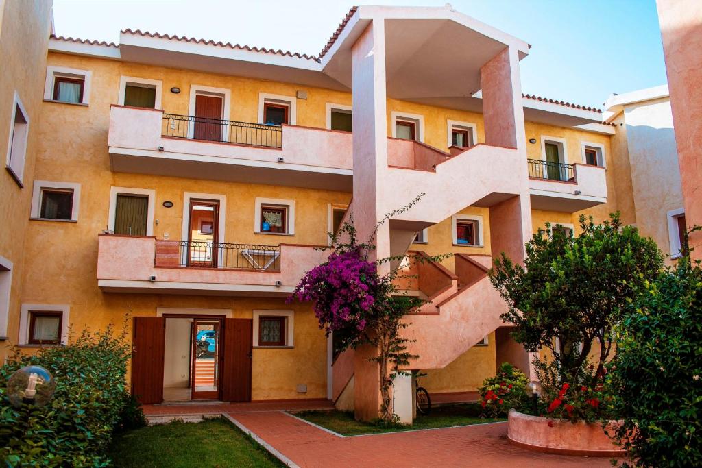 - un bâtiment avec des escaliers et des fleurs devant dans l'établissement Residence Olimpo, à Santa Teresa Gallura