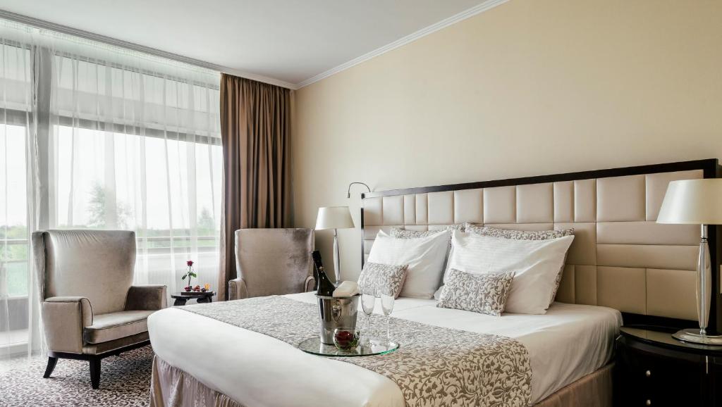 a hotel room with a bed and a table and chairs at Baltic Beach Hotel & SPA in Jūrmala