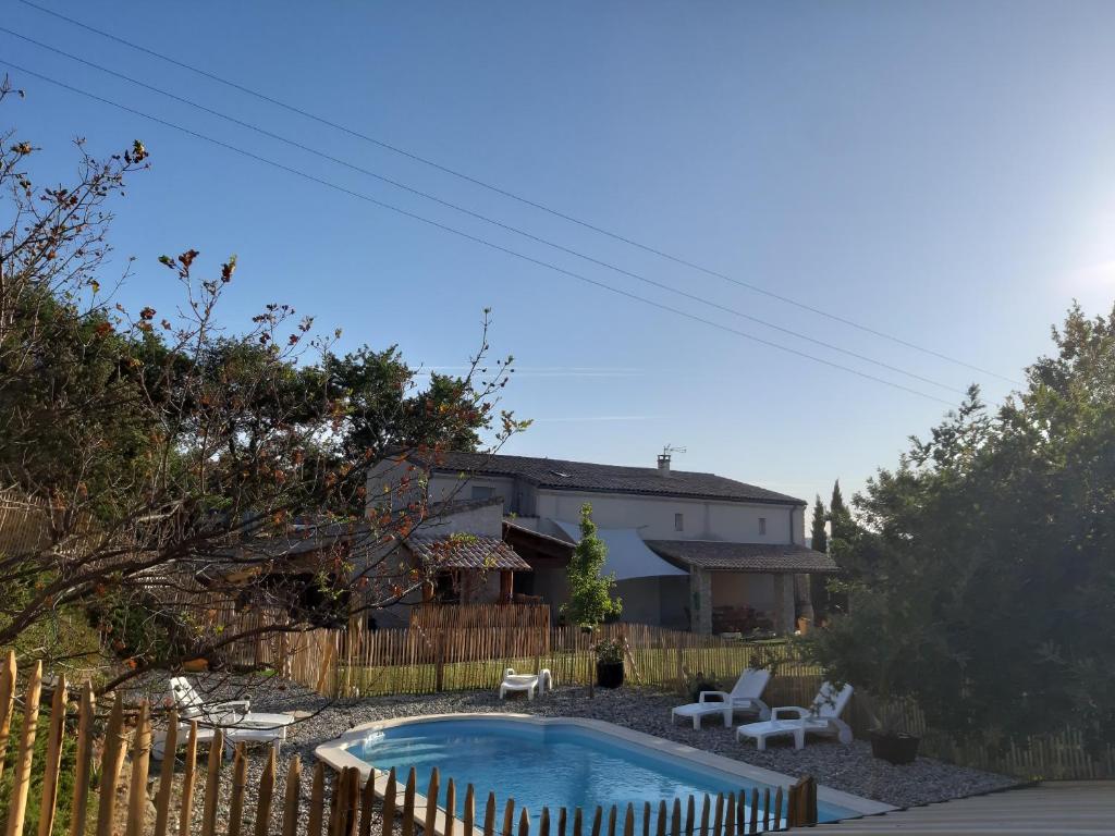 Alba La RomaineにあるChambre d hôte piscine spaの裏庭(椅子とフェンス付きのプールあり)