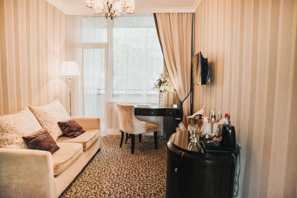 a living room with a couch and a piano at Baltic Beach Hotel & SPA in Jūrmala