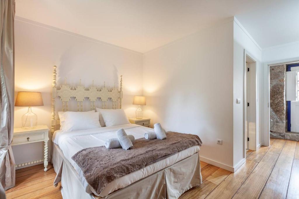 um quarto com uma grande cama branca e 2 almofadas em Eido do Carvalhoso - Casa de Campo em Arcos de Valdevez em Arcos de Valdevez