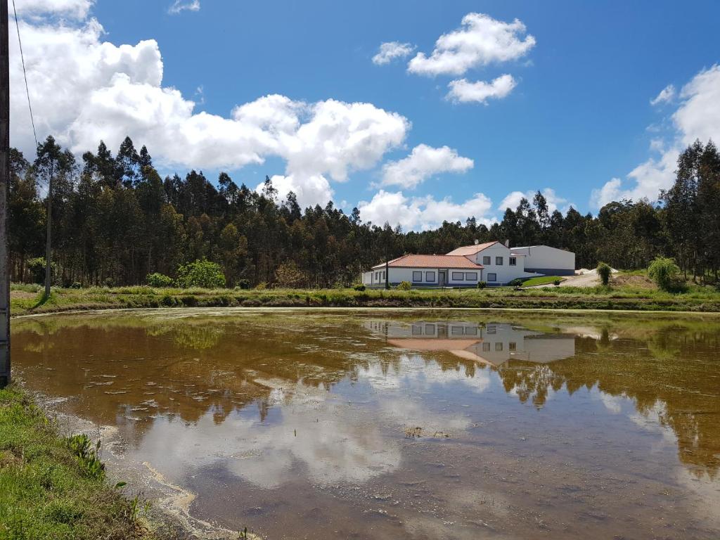 una casa se refleja en un estanque frente a una casa en Quinta do Vale Vendeiro en Figueira da Foz