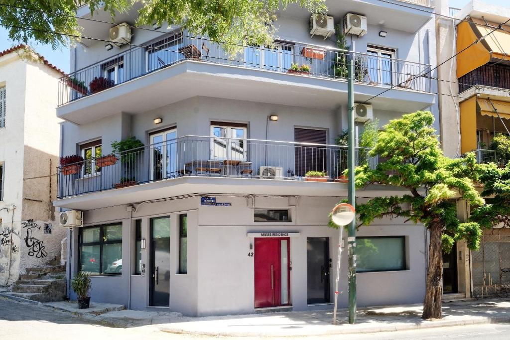 アテネにあるミューゼス レジデンスの赤いドア付きのアパートメントビル
