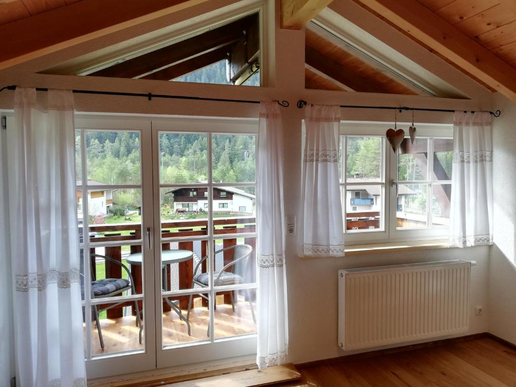 a room with windows and a view of a balcony at Eddy ´s Panorama Suite in Stanzach