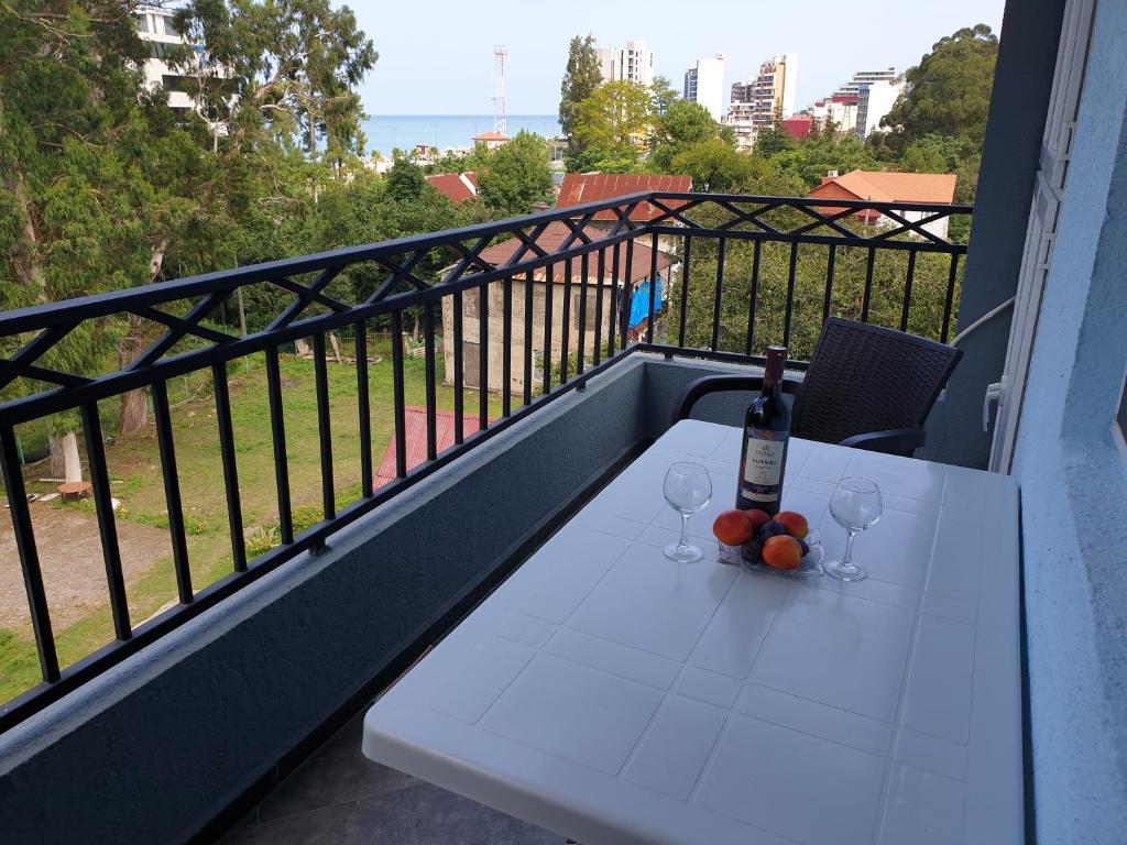 einen Tisch mit einer Flasche Wein und Gläsern auf dem Balkon in der Unterkunft Apartment near the Beach Batumi-Gonio in Gonio