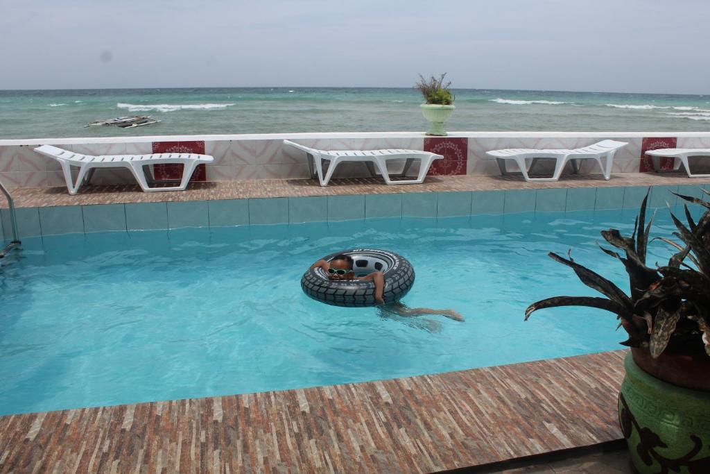 a man swimming in a pool with a tire in the water at Germaroze in Oslob