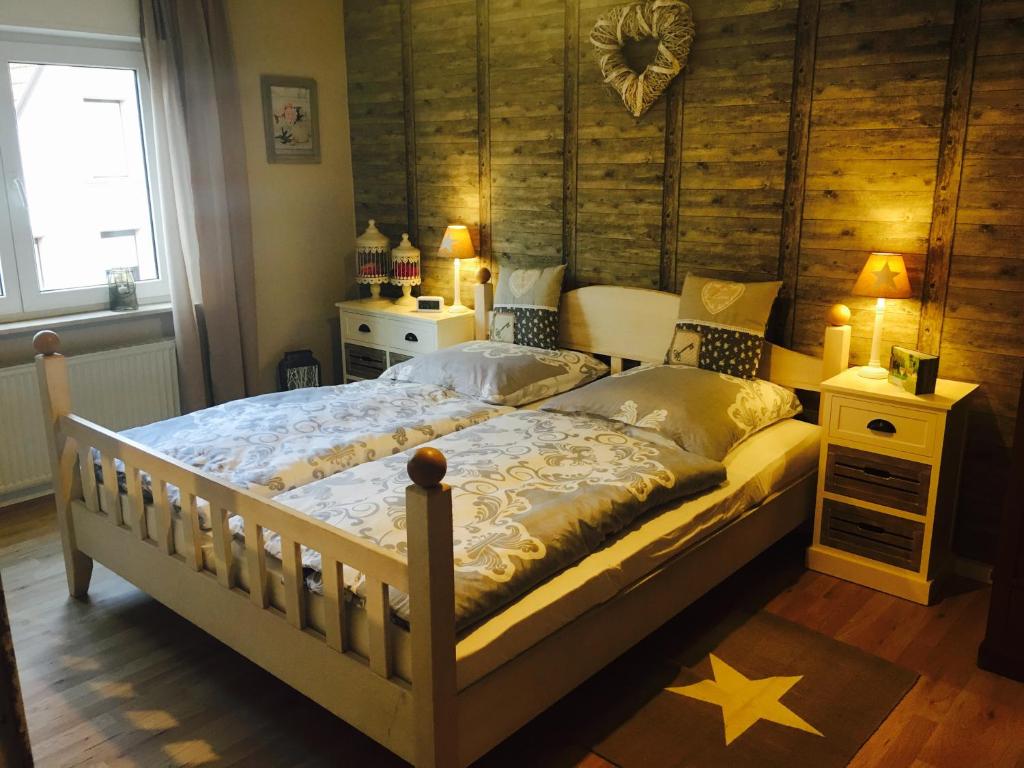 a bedroom with a bed and a wooden wall at Gästehaus Sellemols Ferienwohnung Küfer in Heuchelheim-Klingen