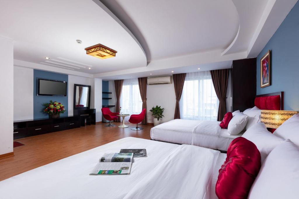 Hanoi Amore Hotel & Travel في هانوي: غرفة فندقية بسريرين وتلفزيون بشاشة مسطحة