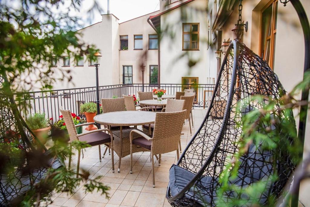 a patio with tables and chairs on a balcony at Hotel Hubertus Rzeszów in Rzeszów