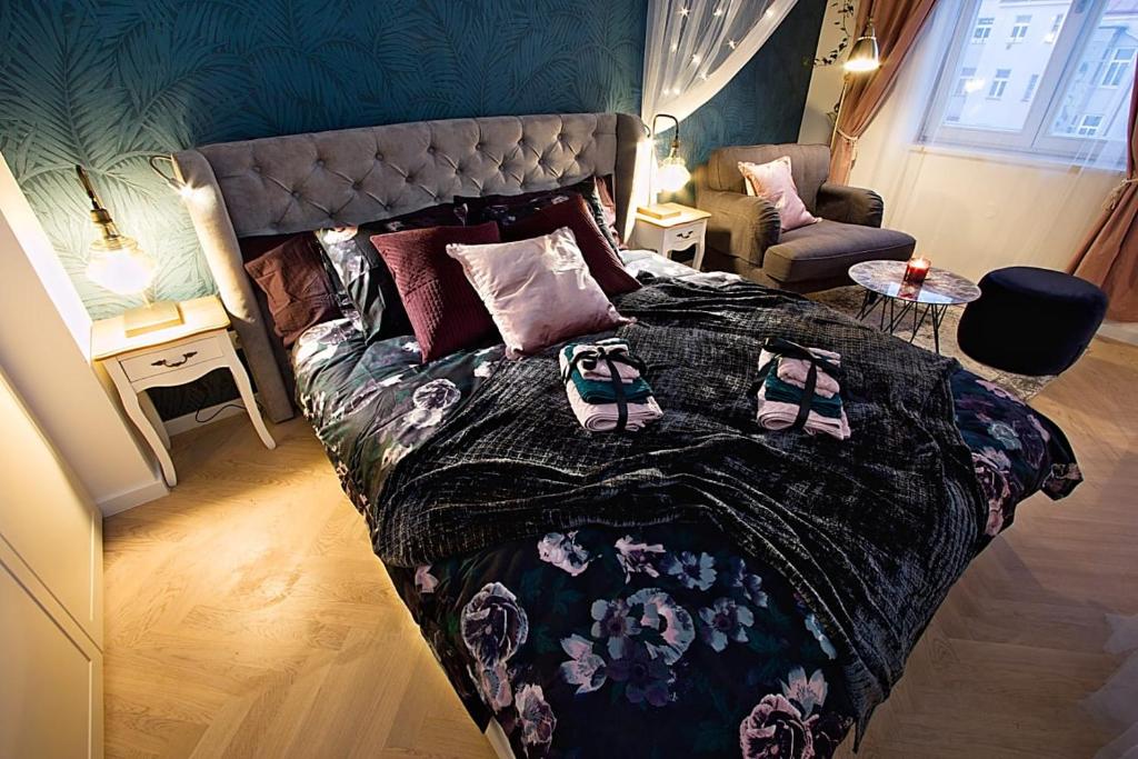 Romantic designer apartment Prague في براغ: غرفة نوم عليها سرير وعليها حذاء