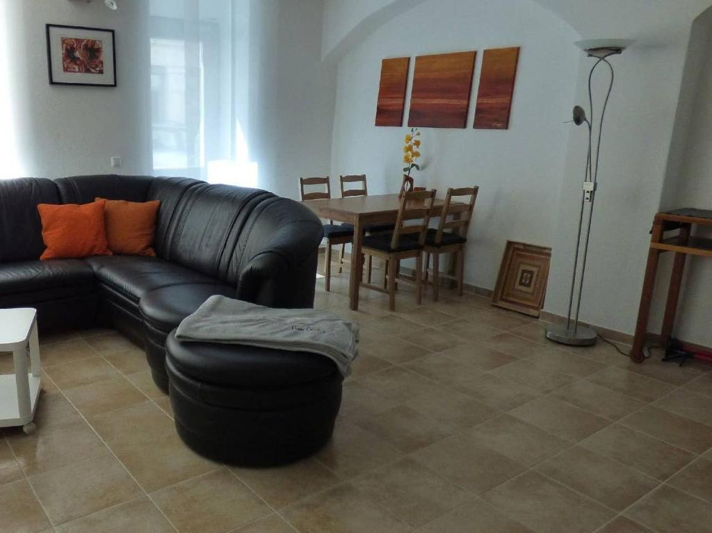 a living room with a black leather couch and a table at Pirna-Apartment in Pirna