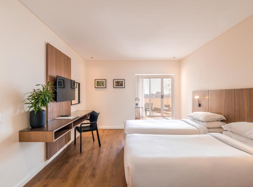 a hotel room with two beds and a desk at The President Hotel Cairo in Cairo