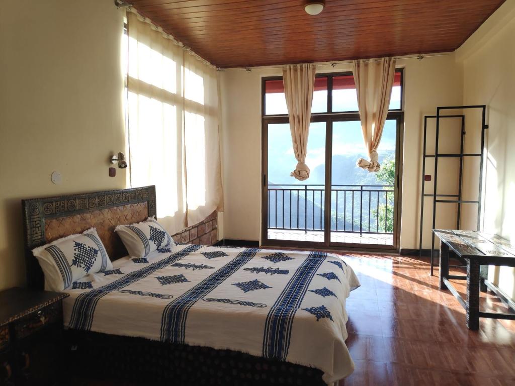 a bedroom with a bed and a large window at Merkeza Guest House in Lalībela