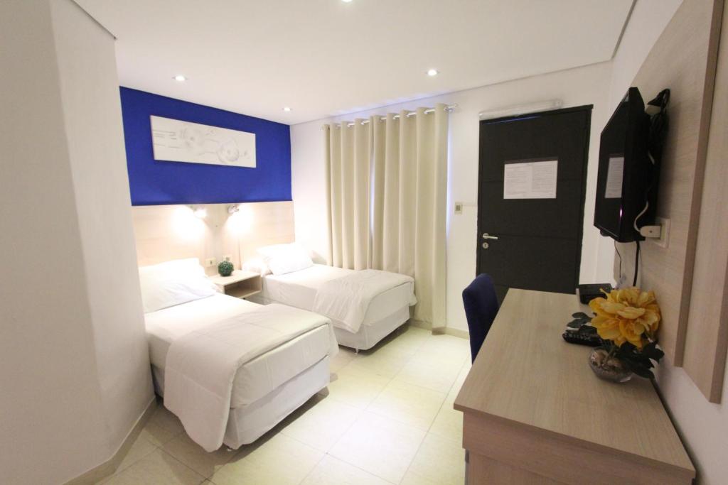Ліжко або ліжка в номері Danieri Asunción Hotel