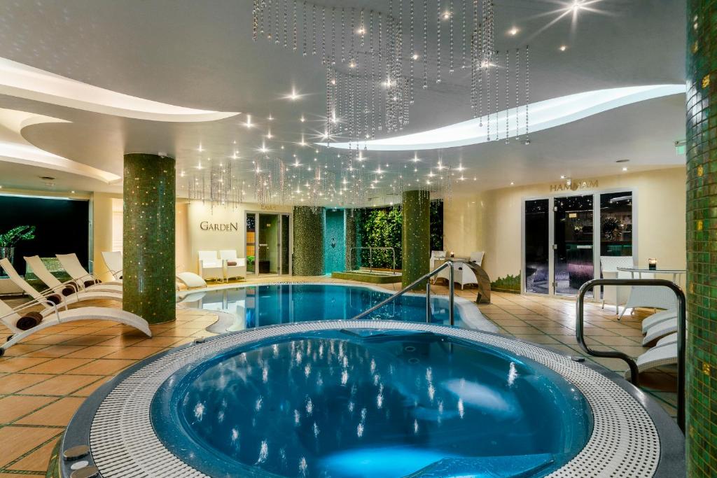 a large pool in a hotel room with chairs at Baltic Beach Hotel & SPA in Jūrmala