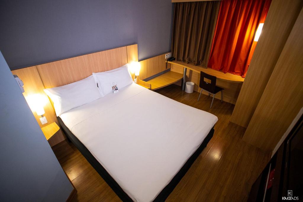 ibis Petrolina في بترولينا: غرفة نوم مع سرير أبيض كبير ومكتب