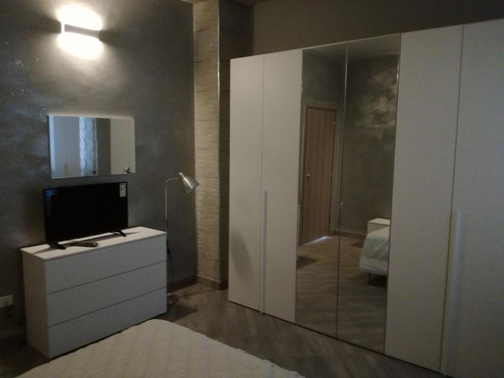 bagno con specchio e TV su un comò di Affittacamere New Lifestyle ad Alberoro