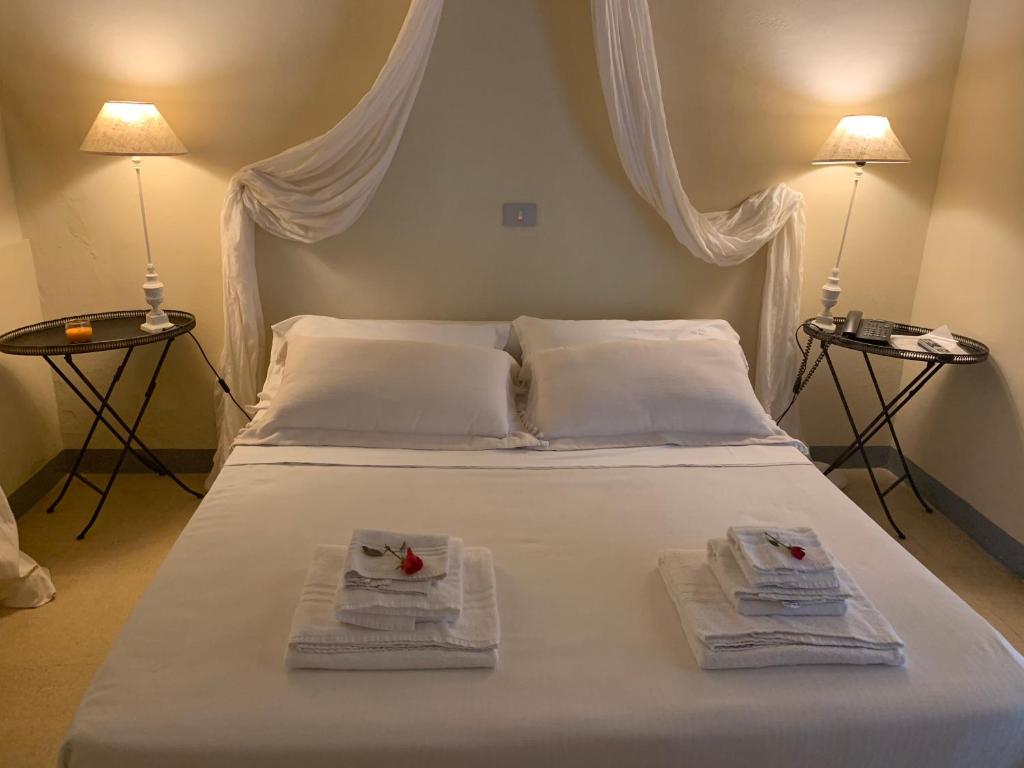 a white bed with two towels and two lamps at Villa Gruccione in Fossombrone