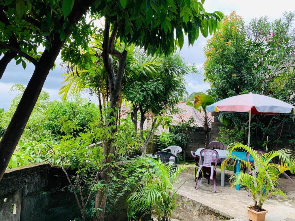 a patio with tables and chairs and an umbrella at Jaga's Hill homestay in Kandy