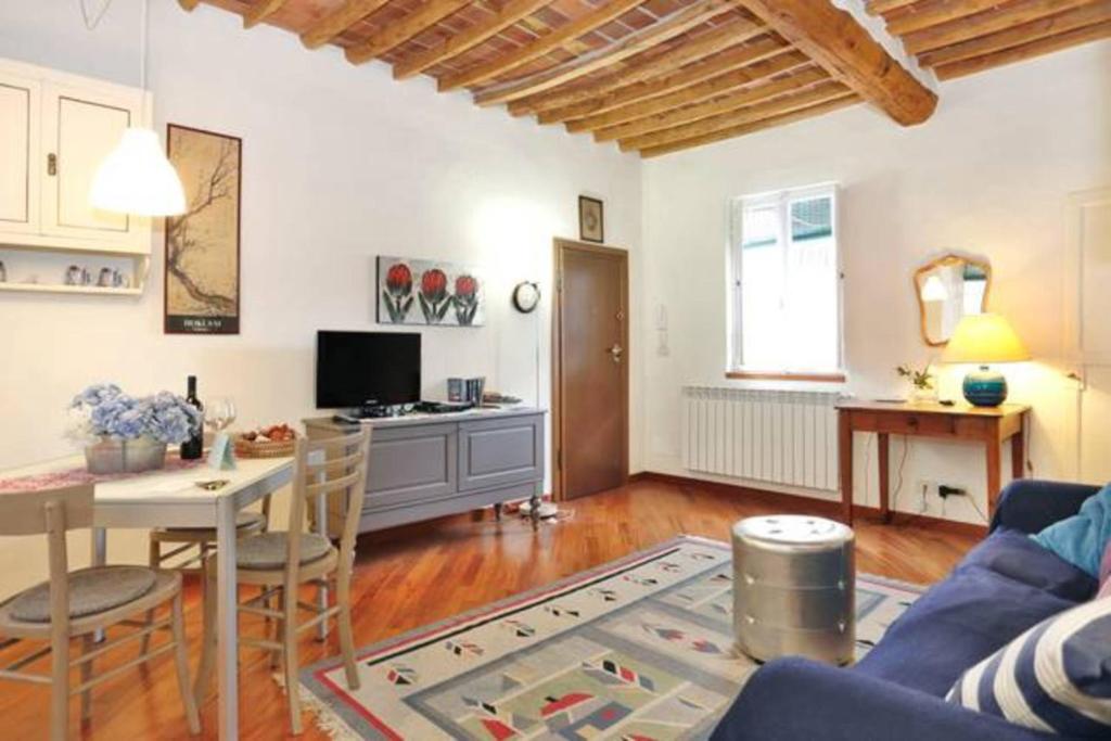 uma sala de estar com um sofá azul e uma mesa em Casa Jole em Lucca