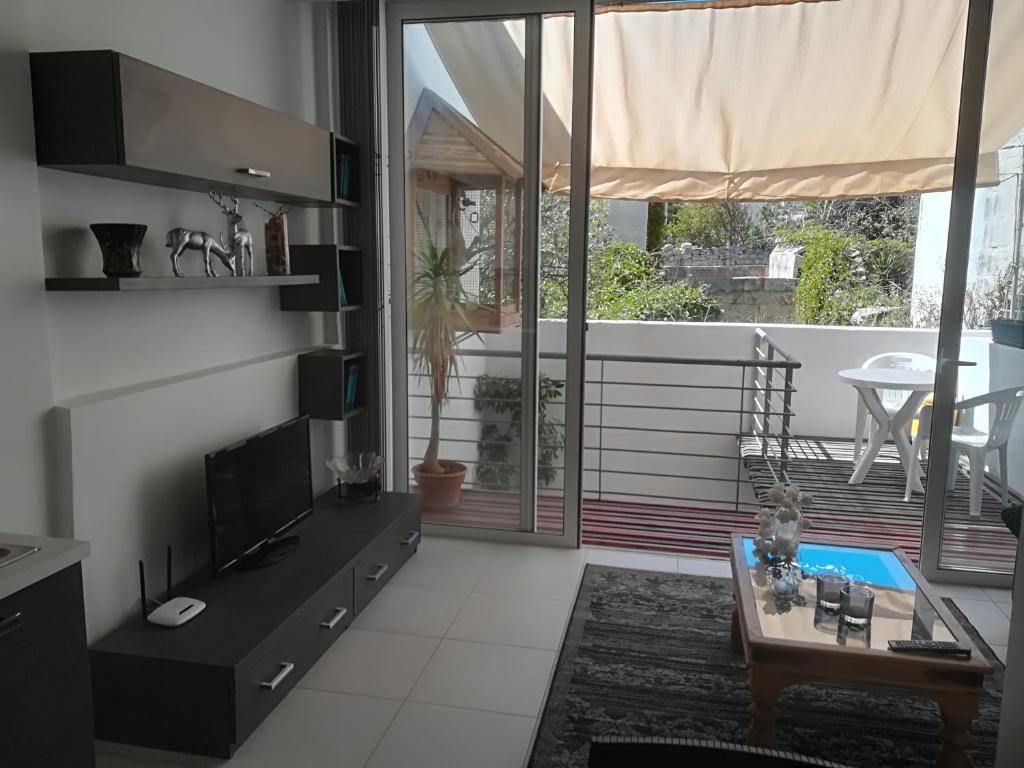 a living room with a television and a table at Luxury Apartment close to seafront in Sliema