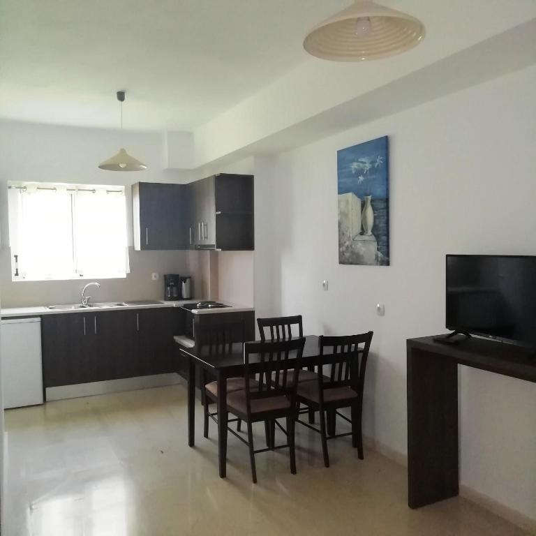 a kitchen and dining room with a table and chairs at Hotel Thisvi in Stalís