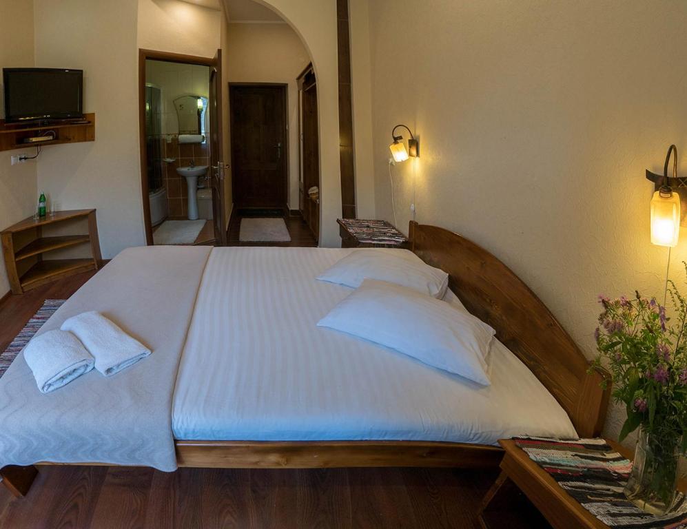 um quarto com uma cama grande e 2 almofadas em Туркомплекс Едельвейс em Sil'