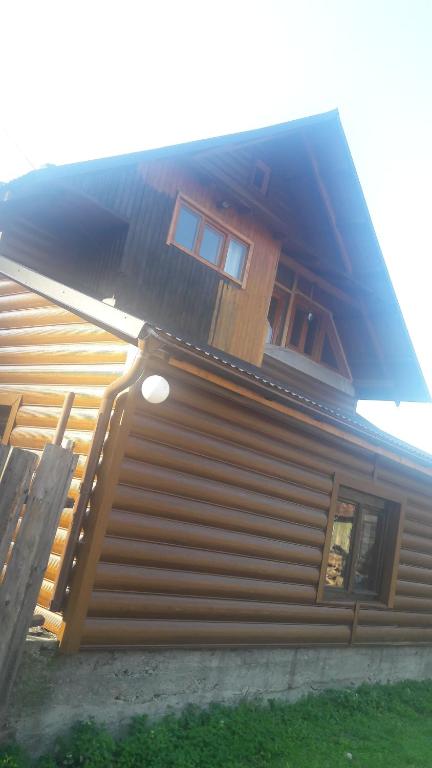 ein Holzhaus mit einer Seitentreppe in der Unterkunft У Оксани in Kvasy