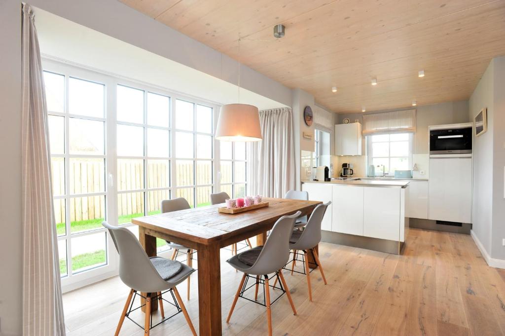 a kitchen and dining room with a wooden table and chairs at Luk Hüs in Westerland (Sylt)