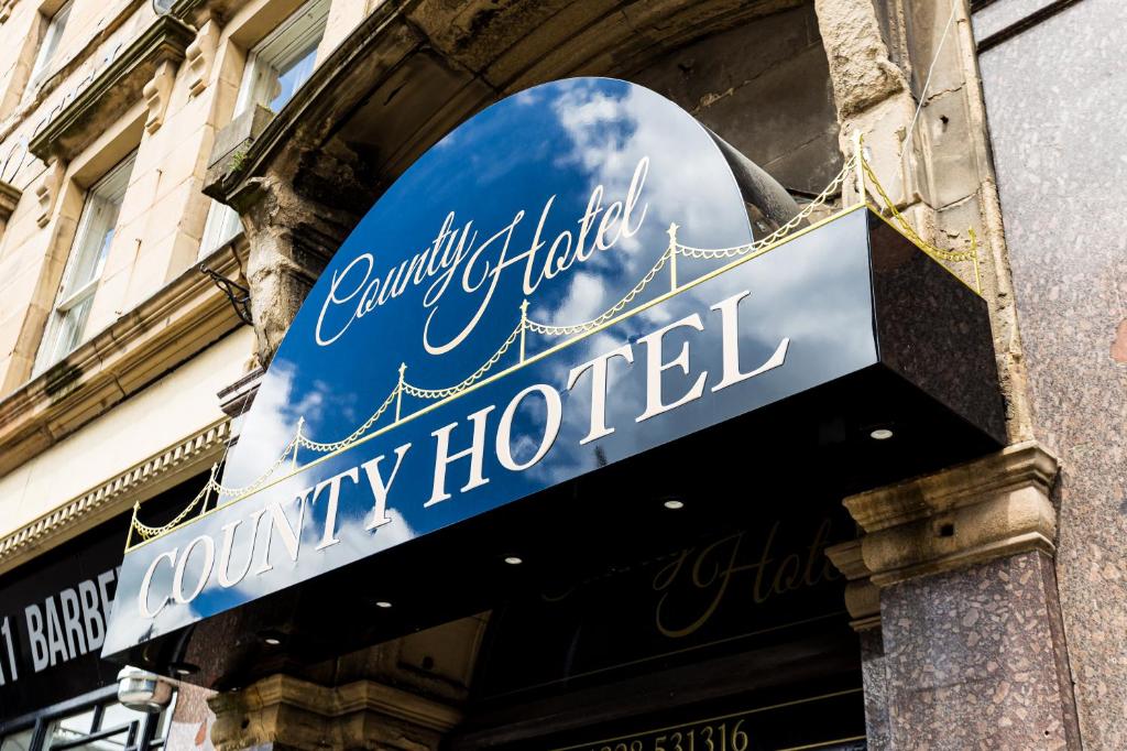 una señal para un hotel de lujo al lado de un edificio en The County Hotel en Carlisle