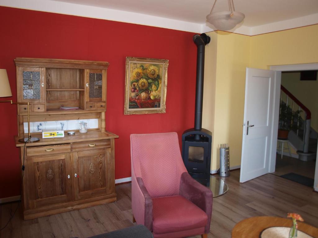 a living room with a chair and a wood stove at Ferienhaus Maria in Vinningen