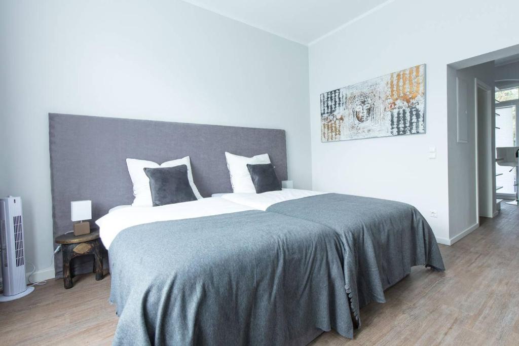 een slaapkamer met een groot bed met een grijs hoofdeinde bij BEJING · CHILLINGHOUSE # 2, 3 Min. vom ICE, NETFLIX; Balkon in Siegburg