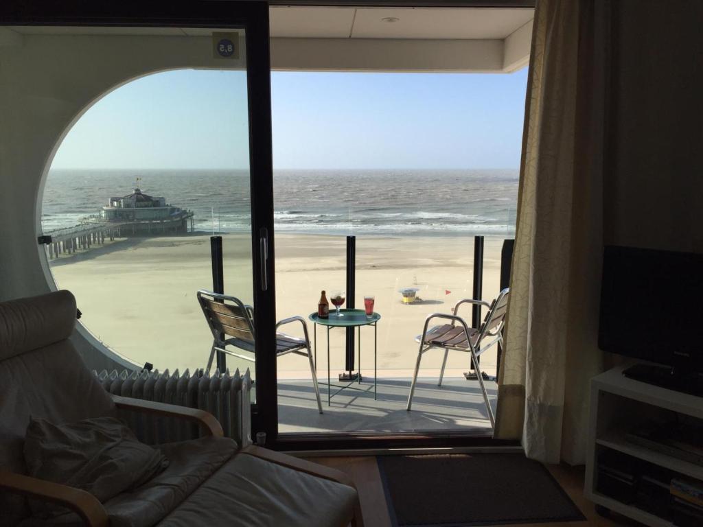 a living room with a view of the beach at Isola Bella Blankenberge in Blankenberge