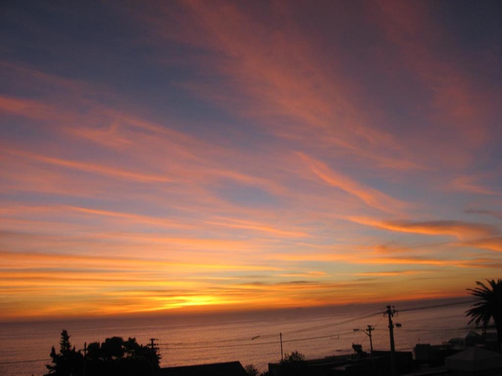 a sunset in the sky over the ocean at 3 On Camps Bay in Cape Town