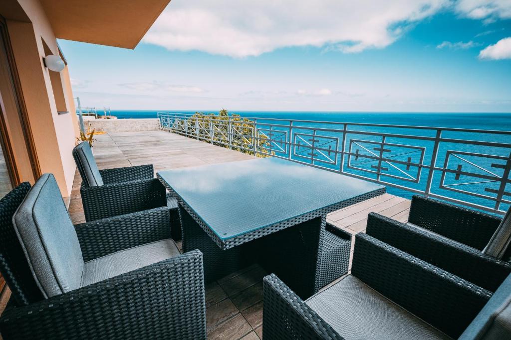 - un balcon avec des chaises et une table donnant sur l'océan dans l'établissement Casa Falésia, à Caniço