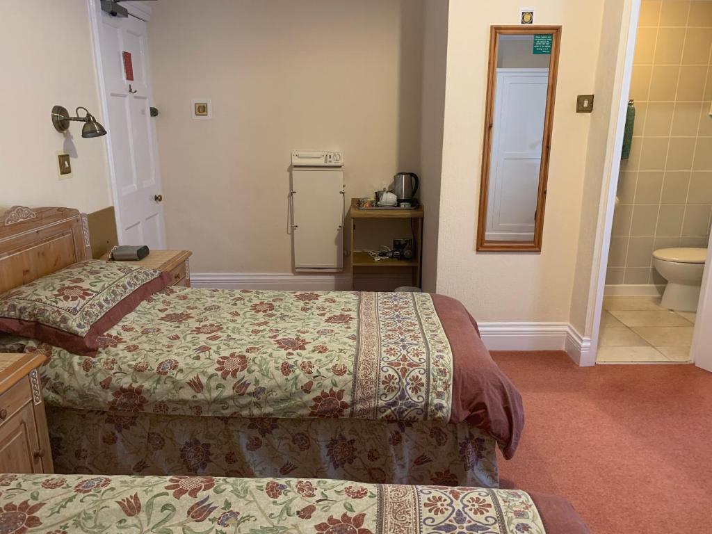 チェスターにあるGreen Gables Guest Houseのベッド2台とバスルームが備わるホテルルームです。