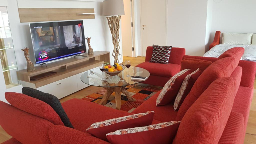 sala de estar con sofá rojo y TV en Loft #11 mit großer Loggia und Terrasse, en Viena