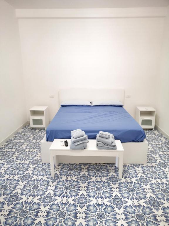 sypialnia z łóżkiem z niebieską pościelą i niebieskimi kafelkami w obiekcie Calise guest house B senza balcone w mieście Procida