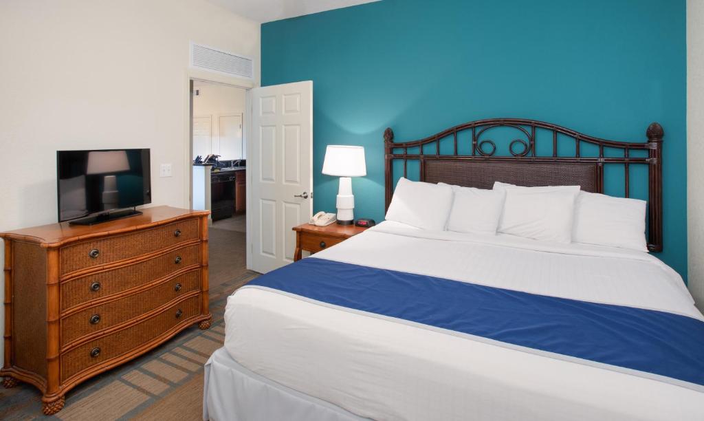 a bedroom with a bed and a tv on a dresser at Lake Buena Vista Resort Village and Spa, Near Disney in Orlando