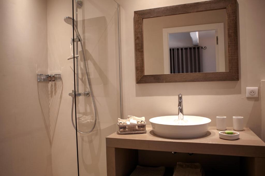 a bathroom with a sink and a shower with a mirror at Les Pins de l&#39;Escalet in Ramatuelle