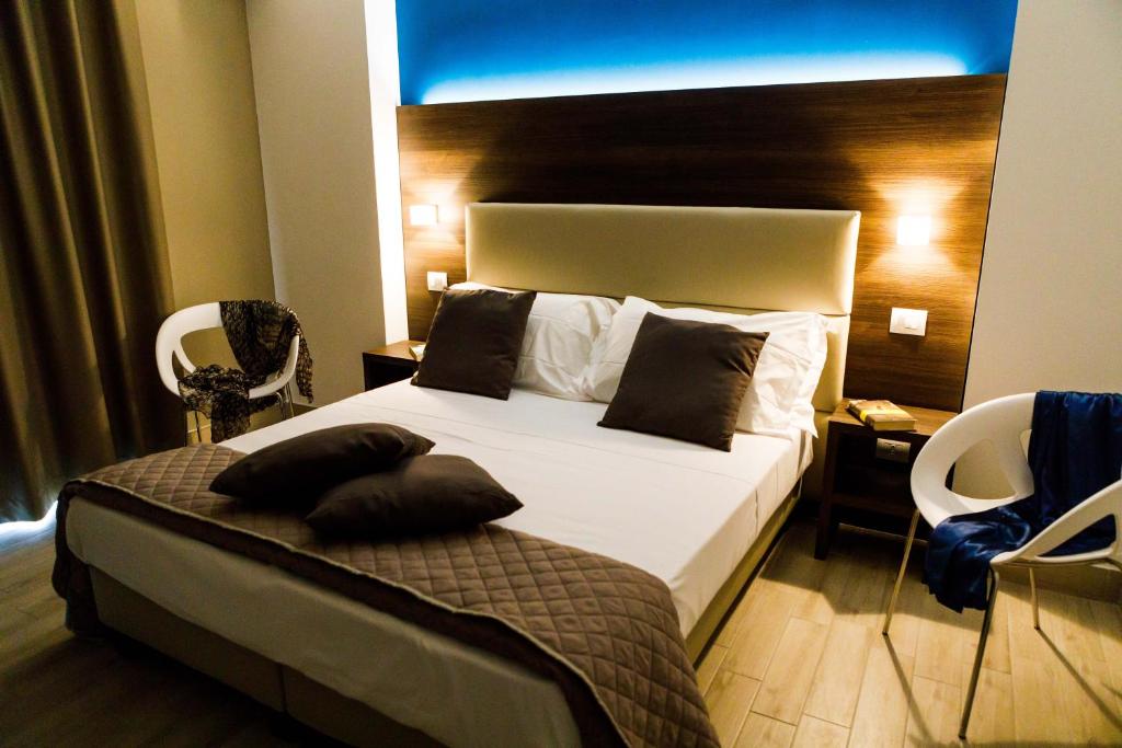 een slaapkamer met een groot wit bed met een blauw licht bij Vignadonica Resort in Fisciano