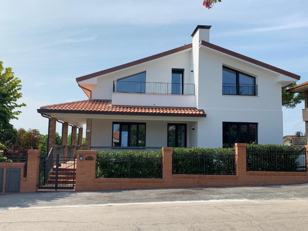 a white house with a fence in front of it at Casa Cervi in Gabicce Mare