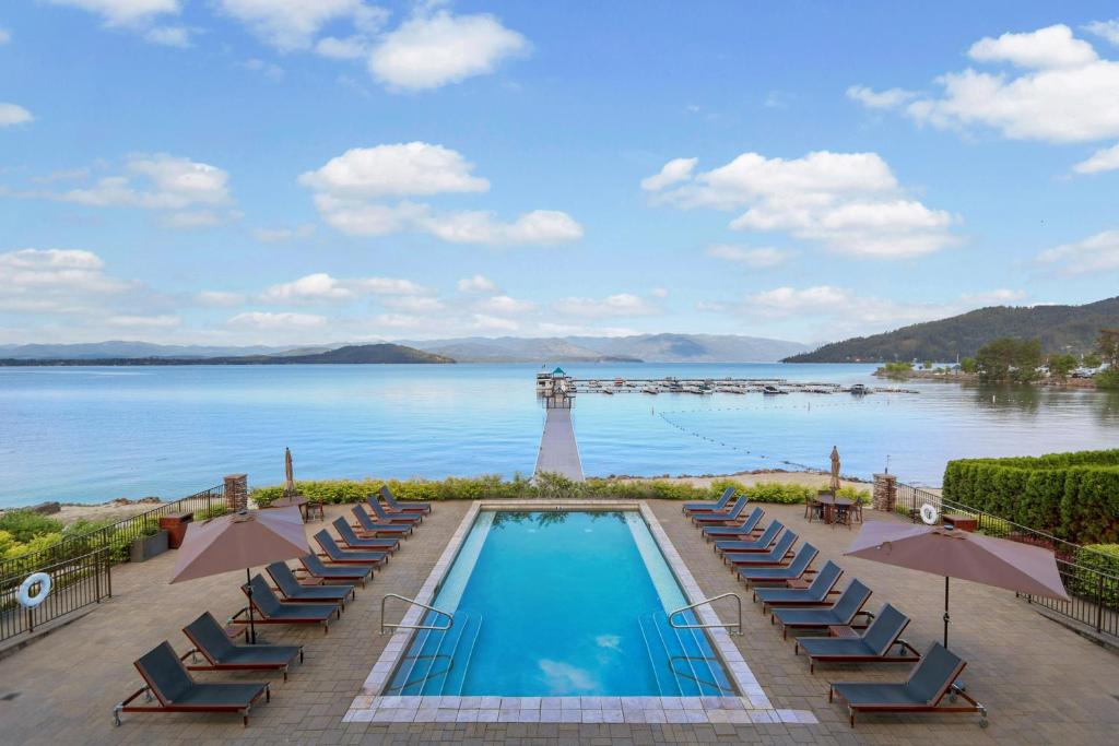 a swimming pool with chairs and a pier on the water at Seasons at Sandpoint in Sandpoint