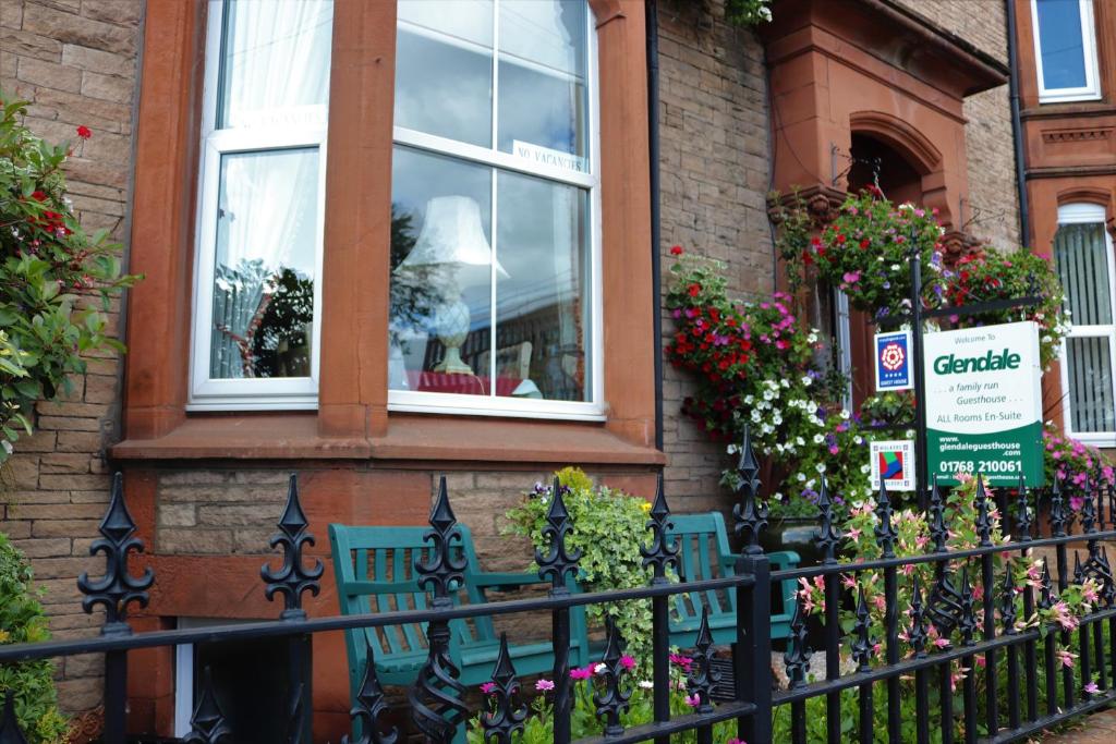 une maison avec une clôture et des fleurs devant elle dans l'établissement Glendale Guest House, à Penrith