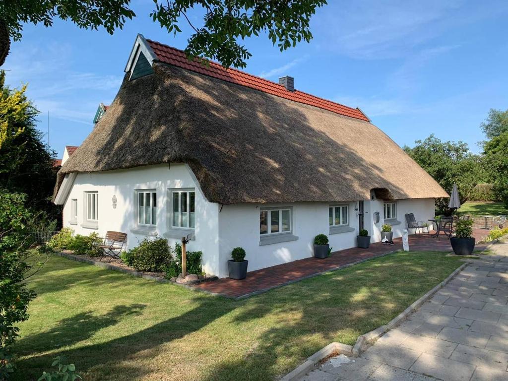 een huisje met een rieten dak bij Traumhaus am Weserstrand in Elsfleth